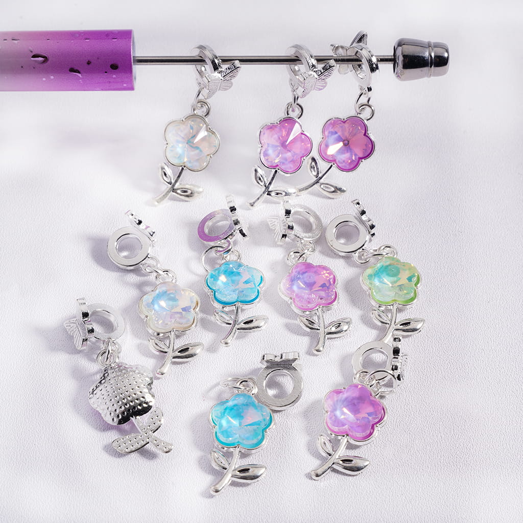 Silver earrings with colorful flower charms on a white background