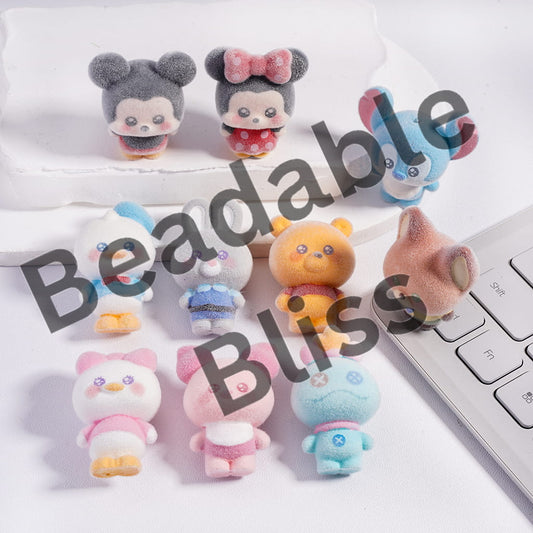 Set of small plush toys on a desk with a keyboard