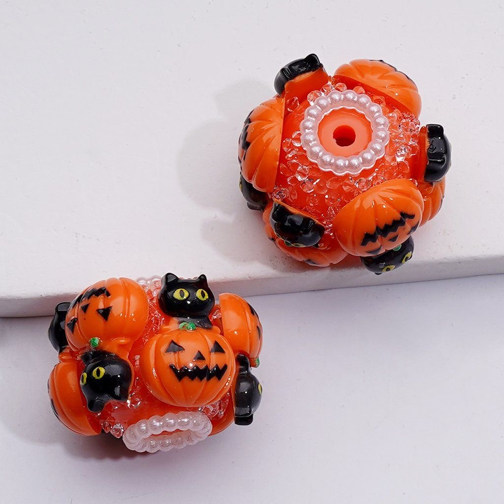Halloween-themed earrings with orange pumpkins and black cats on a white background

